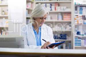 Pharmacist writing on clipboard