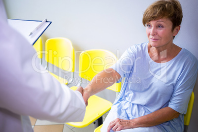 Doctor shaking hand with patient in waiting room