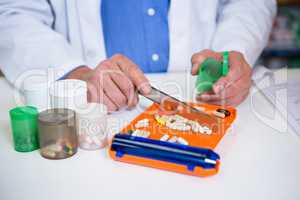 Pharmacist putting pills in container