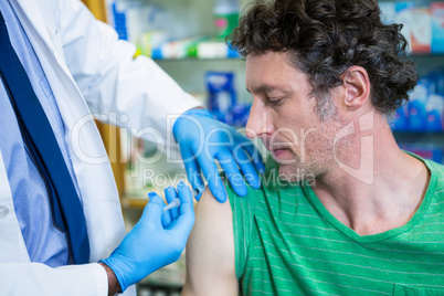 Pharmacist giving injection to patient