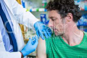 Pharmacist giving injection to patient