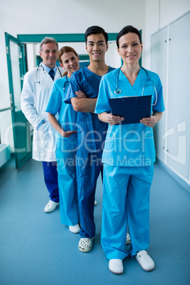 Portrait of smiling surgeons and doctors standing in corridor