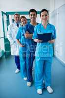 Portrait of smiling surgeons and doctors standing in corridor