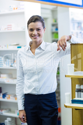 Smiling pharmacist standing in pharmacy