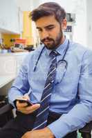 Doctor text messaging on mobile phone