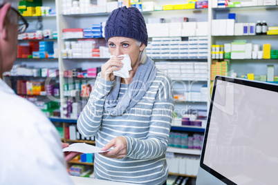 Customer sneezing while giving prescription to pharmacist