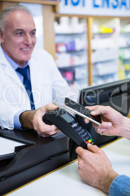 Customer making payment through smartphone in payment terminal