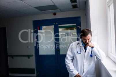 Sad doctor standing in corridor