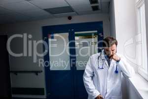 Sad doctor standing in corridor