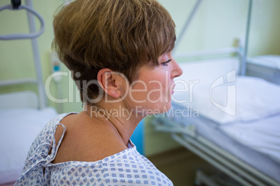 Close-up of sad senior patient sitting on a bed