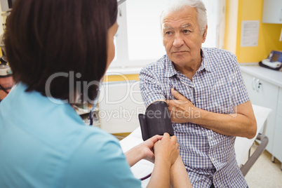 Female doctor checking blood pressure of patient