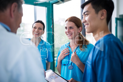 Doctor and surgeons interacting wit each other in corridor