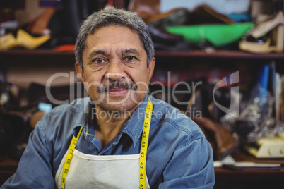 Portrait of shoemaker standing in workshop