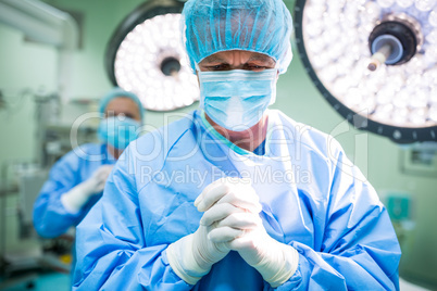 Surgeon praying in operation room while operation