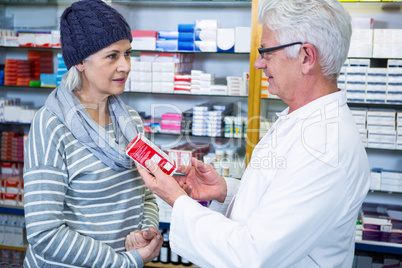 Pharmacist showing medicine to customer