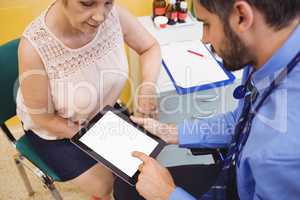 Doctor discussing with patient over digital tablet