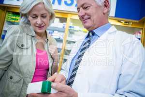 Pharmacist showing medicine to customer