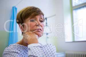 Close-up of sad senior patient sitting on a bed