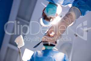Surgeons holding surgical clamp with cotton swab in operation ro