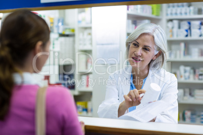 Pharmacist assisting the bottle of drug to customer