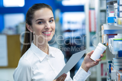 Pharmacist holding prescription while checking medicine in pharm