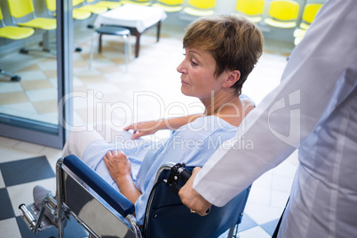 Doctor pushing senior patient on wheelchair