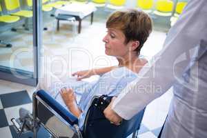 Doctor pushing senior patient on wheelchair