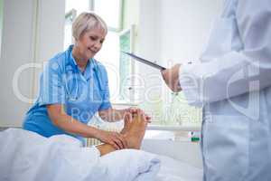 Nurse giving foot treatment to patient