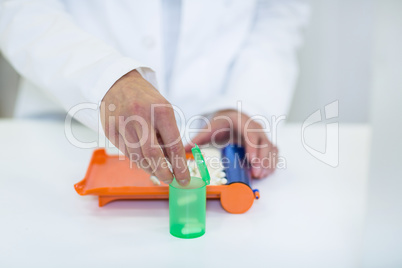 Pharmacist putting pill in container at pharmacy