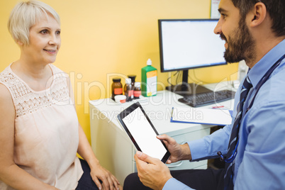 Doctor discussing with patient over digital tablet