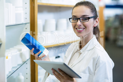 Pharmacist holding digital tablet while checking medicine in pha