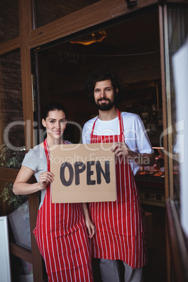 Couple holding open signboard