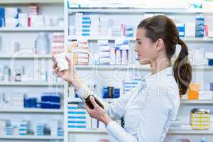 Pharmacist checking a bottle of drug