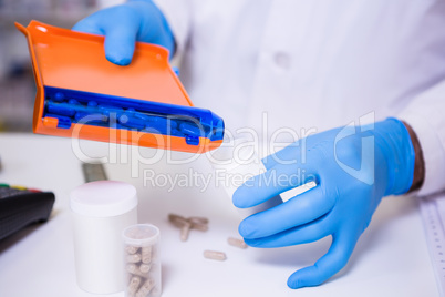 Pharmacist putting pills in container
