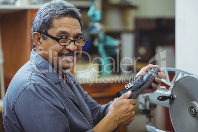 Portrait of shoemaker using sewing machine