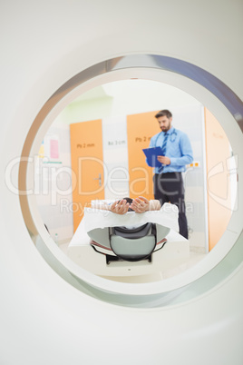 Doctor reviewing chart of patient about to have mri scan