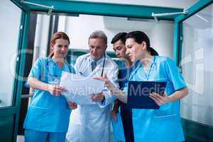 Doctor and surgeons discussing with report in surgical room