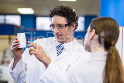 Pharmacist assisting the bottle of drug to customer