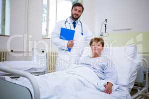 Smiling doctor and patient looking at camera in hospital