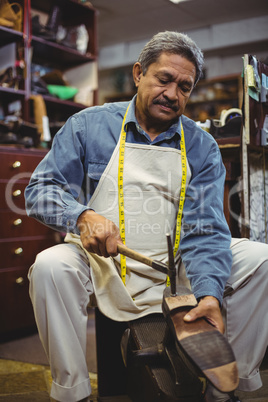Shoemaker hammering on a shoe