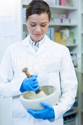 Pharmacist grinding medicine in mortal and pestle
