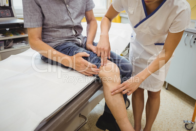 Female doctor examining patients knee