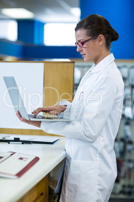 Pharmacist using laptop in pharmacy