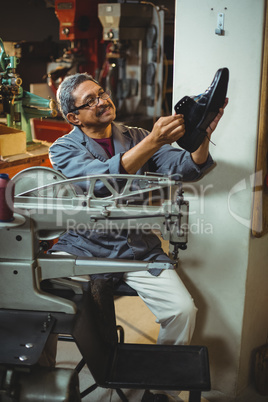 Shoemaker examining a shoe