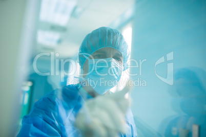 Doctor looking through a glass window