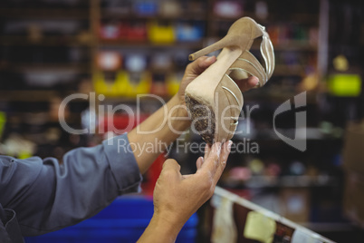 Shoemaker examining a high heel