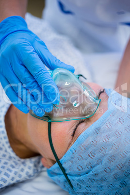 Nurse placing an oxygen mask on the face of a patient