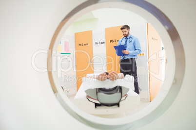 Doctor reviewing chart of patient about to have mri scan