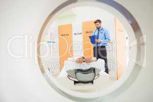 Doctor reviewing chart of patient about to have mri scan