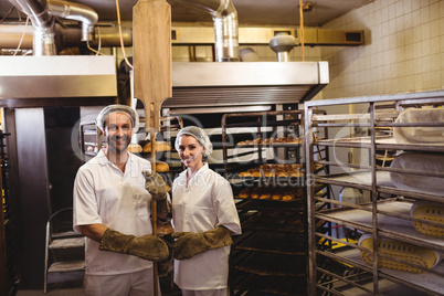 Portrait of female and male baker standing together